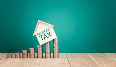 A small house model on coins - Property Tax